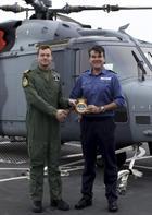 CO 700W Lt Cdr Simon Collins gives squadron crest to Dragon's CO Captain Ian Lower