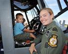 Lt Danielle Welch a student on 702 NAS with a young visitor in the pilot's seat of a Lynx HMA Mk8