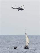 HMS Argyll's Lynx helicopter hovers overhead while the ship's boarding team approaches the vessel