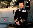 Commander Phil Richardson, Commanding Officer of 815 Naval Air Squadron stands in front of a newly d