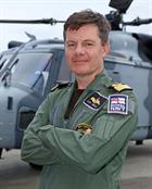 Commodore Nicolas Tindal, the new Commanding Officer of RNAS Yeovilton in front of a Wildcat helicop
