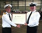 Rear Admiral Keith Blount presents Warrant Officer Paul Roe with Royal Warrant Parchment
