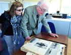 Sue Pooley and Capt Howard DSC looking through press cuttings from his time at Culdrose
