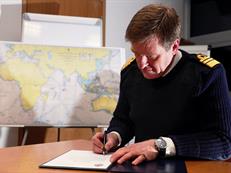 Fleet Commander, Vice Admiral Benjamin John Key, CBE RN signs the Commissioning Order cert