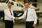 Lt Cdr Barber (L) handing over the reigns to Lt Cdr Whitson-Fay (Avenger aircraft in the background)