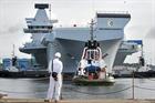 Tugs pull HMS Queen Elizabeth from the flooded dry dock