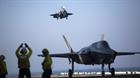 A sailor aboard the USS Wasp (LHD-1) signals to the pilot of an F-35B Lightning II Joint Strike Figh