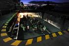 Royal Marines prepare to disembark in CHF Sea King helicopters from HMS Illustrious at night