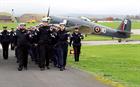 Personnel march to the service with a Sea fury in the background