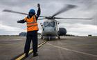 Leading Seaman Paul Rendle signals to the first Crowsnest helicopter to take off