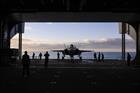 The F-35 is moved by the ship lift to the hangar deck