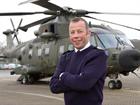 Warrant Officer 1 David Rowlands in front of an RAF Merlin helicopter 